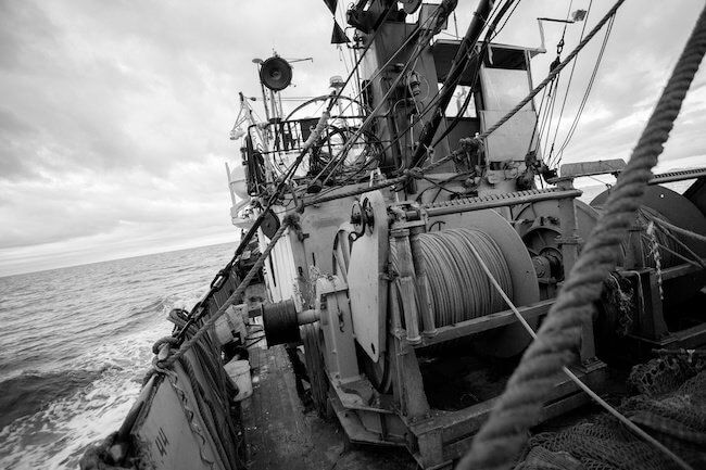 Trawl winch, cables and rigging on a fishing vessel's deck at sea