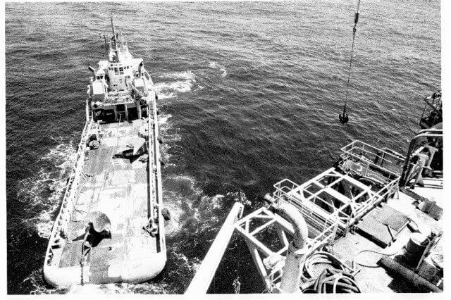 Aerial view of a work boat alongside a vessel at sea