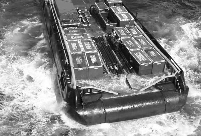 Deck cargo barge pushing through rough water