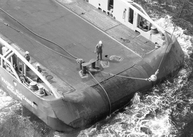 Crew working on the stern deck of a vessel, seen from above